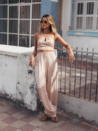 Mulher usando a Calça Cecília Bege da Greenish, com estilo e conforto, em ambiente urbano no calor.
