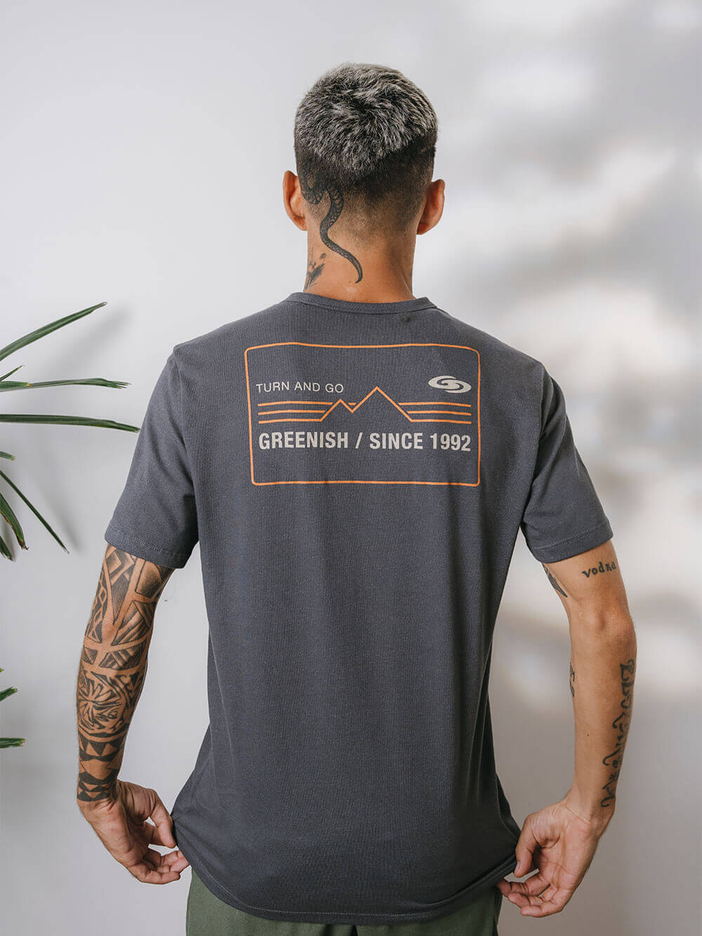 Camiseta Greenish cinza com estampa das montanhas e logo na parte de trás, ideal para o dia a dia.