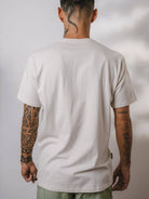 Camiseta Legalize Let's Grow bege da marca Greenish, vista de costas, com detalhes em tatuagem.