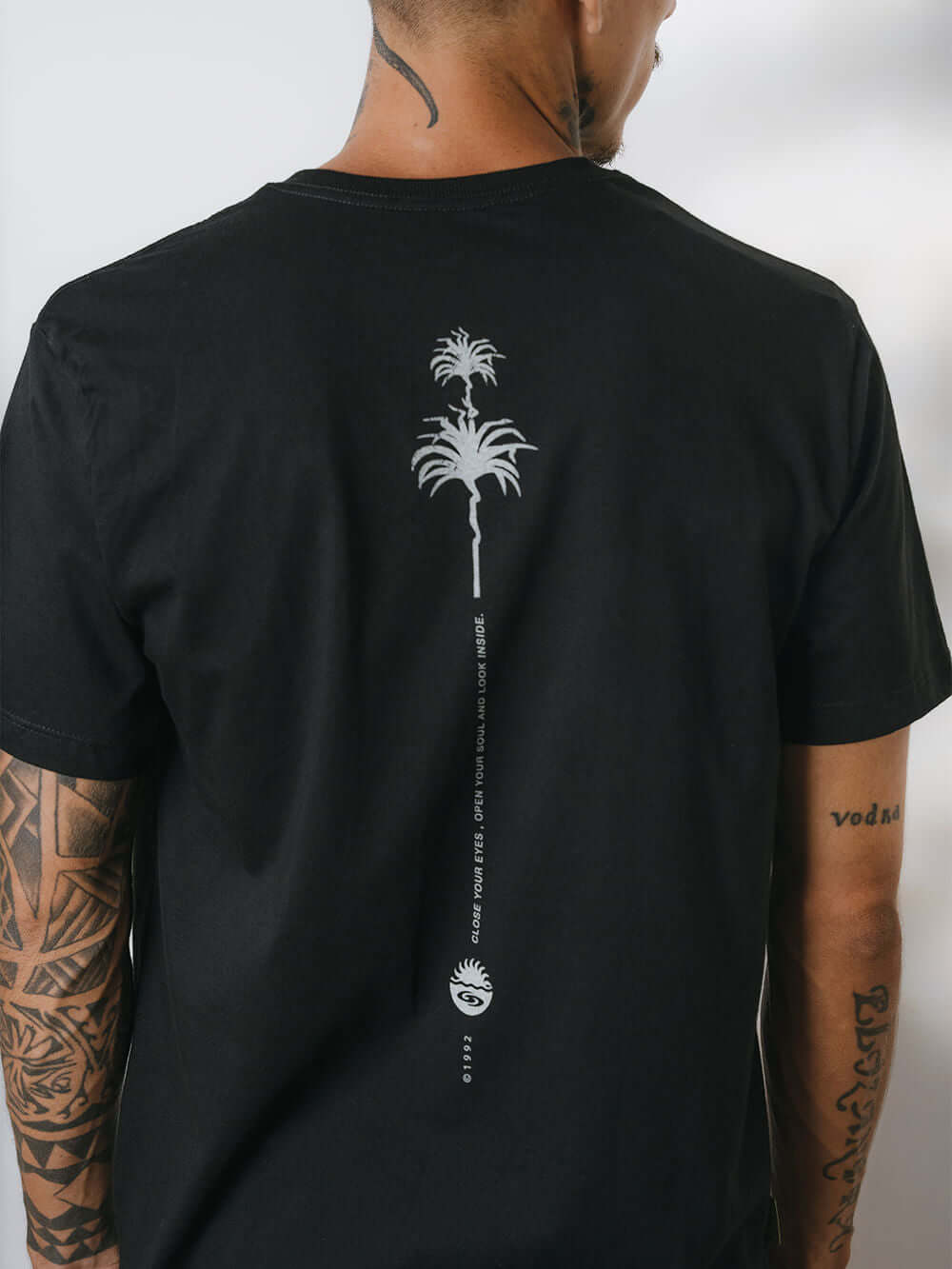 Camiseta Elemental Suns preta da marca Greenish com estampa de palmeiras nas costas, estilo moderno e confortável.