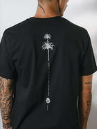 Camiseta Elemental Suns preta da marca Greenish com estampa de palmeiras nas costas, estilo moderno e confortável.