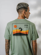 Camiseta KITE SUNSET da Greenish na cor verde, com estampa colorida de sol e ondas.