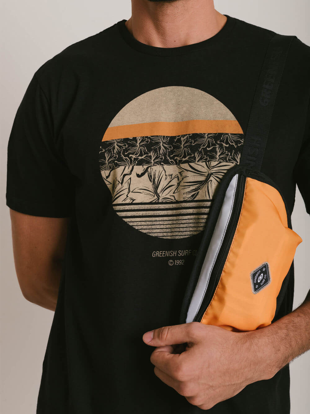 Camiseta preta Greenish com estampa tropical e bolsa laranja, ideal para um estilo casual e confortável.
