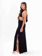 Modelo usando o vestido longo Izzy preto da Greenish, com detalhes de amarração e fenda, exibindo estilo e conforto.