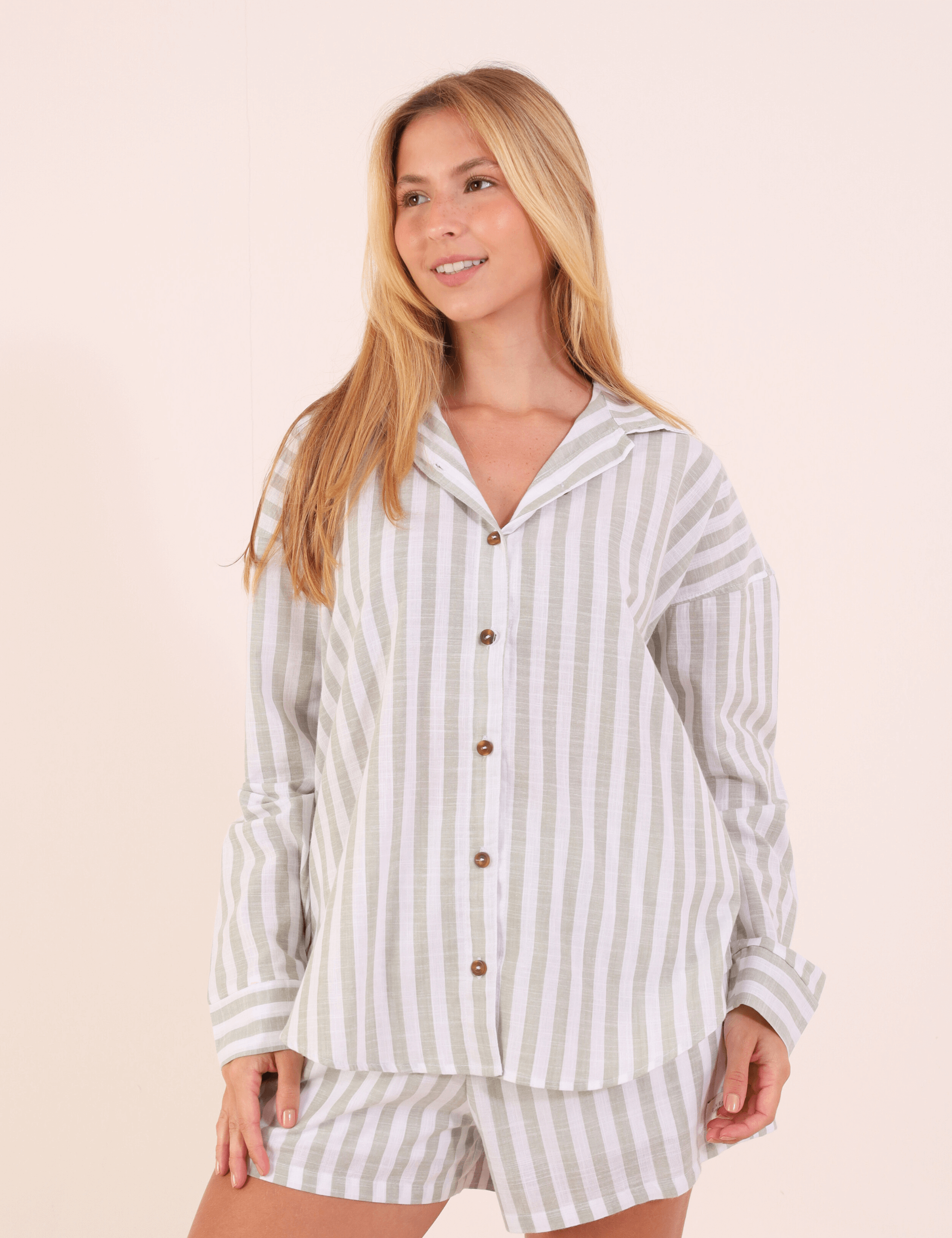 Modelo vestindo Camisa Marine - Verde com listras verticais, mostrando o design clássico e confortável para uso diário ao ar livre.