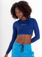 Mujer usando o Colete Cropped Basic da Greenish na cor azul, ideal para praia e atividades aquáticas, com proteção UV.