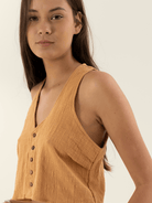Modelo usando blusa de linho alaranjada da marca Greenish, exalando estilo e conforto.