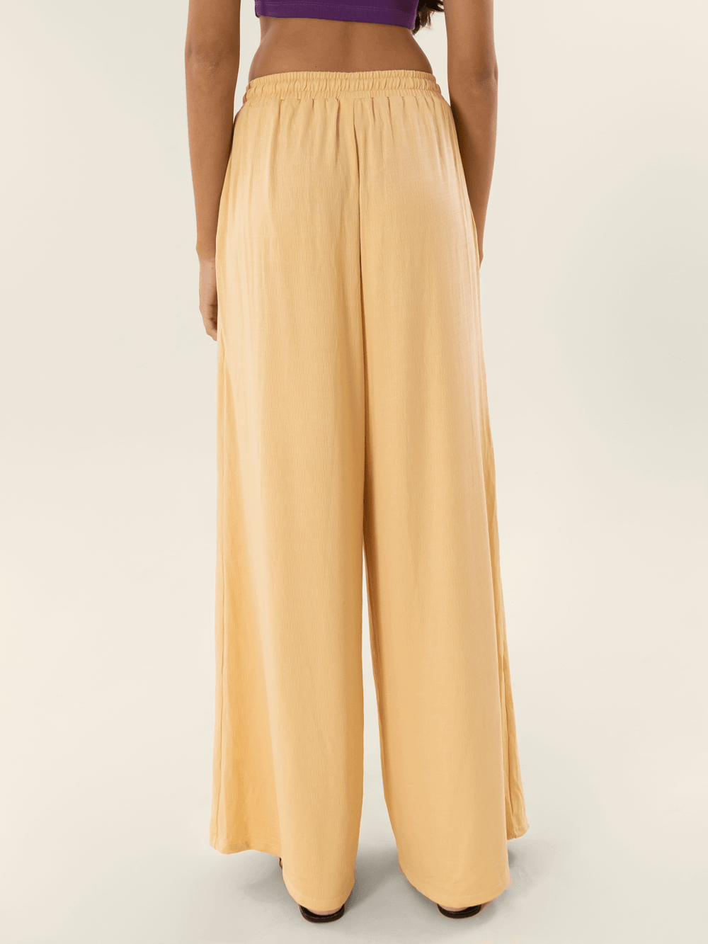 Calça Greta bege da Greenish vista de trás, perfeita para um look confortável e estiloso.