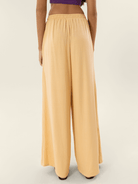 Calça Greta bege da Greenish vista de trás, perfeita para um look confortável e estiloso.