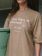 Camiseta oversized Take Care of Yourself da Greenish, em caqui, ideal para dias confortáveis e vibes de surf.