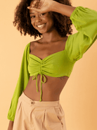Modelo sorridente usando cropped Yamba Verde da Greenish, destacando sua estética vibrante e moderna.