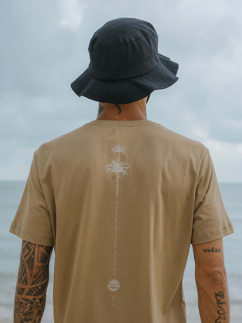 Camiseta Elemental Suns cáqui da Greenish com estampa moderna e design clássico, vista na praia.
