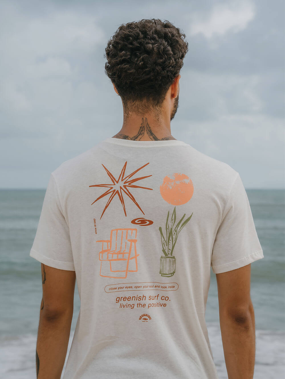 Camiseta Greenish com estampa de elementos naturais, vista de costas, ideal para momentos ao ar livre.