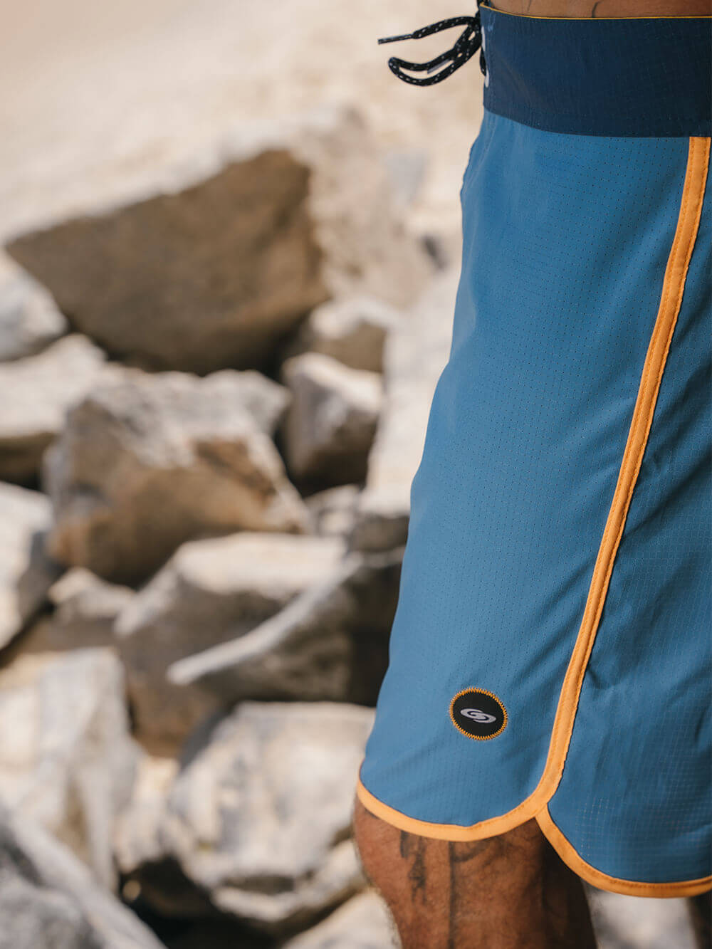Bermuda Retrô Flat Sea Azul da Greenish com detalhes em laranja, perfeita para conforto e performance.