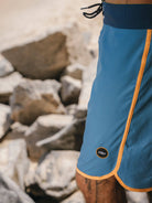Bermuda Retrô Flat Sea Azul da Greenish com detalhes em laranja, perfeita para conforto e performance.