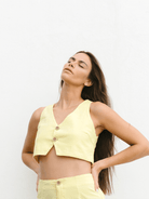 Colete Hazel Yellow da Greenish em modelo cropped com decote em V, destacando estilo e elegância.