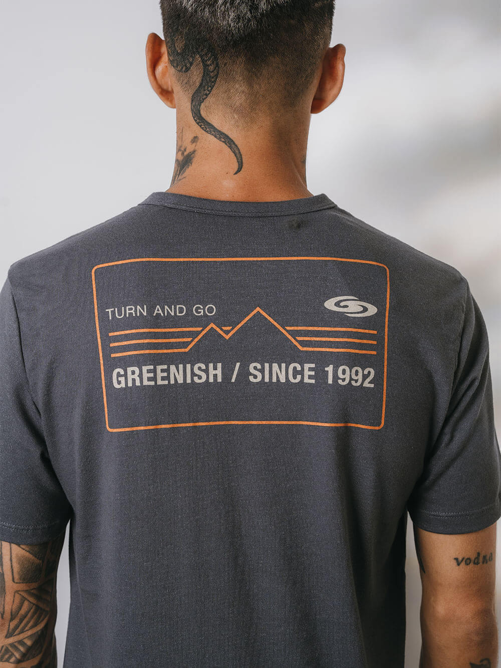 Camiseta Greenish cinza com estampa "Turn and Go" nas costas, perfeita para atividades ao ar livre.