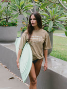 Camiseta oversized Take Care Of Yourself da Greenish em caqui, estilo streetwear, ideal para dias de praia.