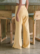 Calça Heaven da Greenish em amarelo, vista traseira, com cadarço de algodão e corte amplo para conforto e estilo.