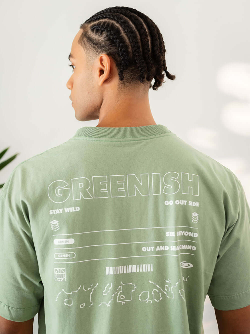 Modelo usando camiseta oversized verde Greenish com estampa exclusiva nas costas.
