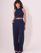 Modelo vestindo Calça Lina Azul Marinho da Greenish em malha 100% algodão, com caimento reto e bolso lateral. Ideal para conforto e estilo.