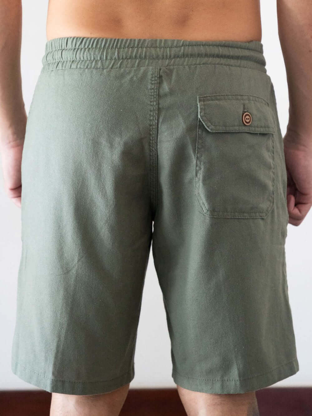 Bermuda relax verde da marca Greenish, vista traseira com detalhe do bolso e elástico na cintura.