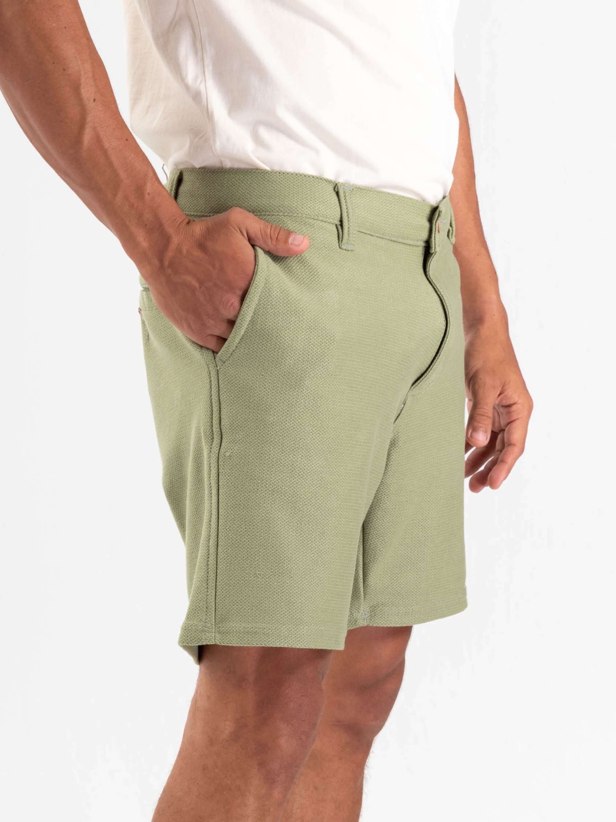 Bermuda Aspen Verde Musgo da Greenish, estilo clássico e moderno, com bolsos e detalhe de costura tripla.