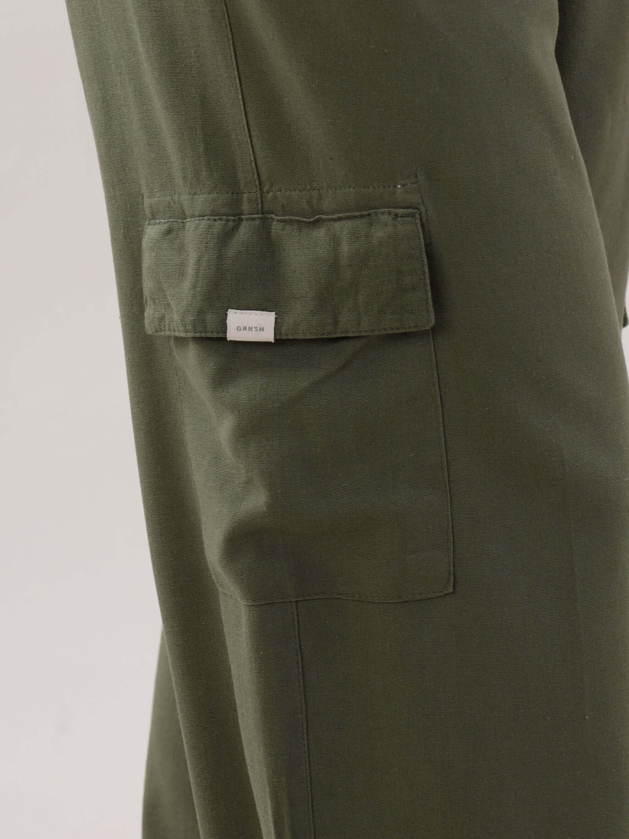 Calça reta cargo Taia da Greenish na cor verde escuro, com detalhe do bolso lateral.