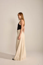 Modelo usando body Célia preto e calça larga em tom claro, exibe look minimalista e elegante da marca Greenish.