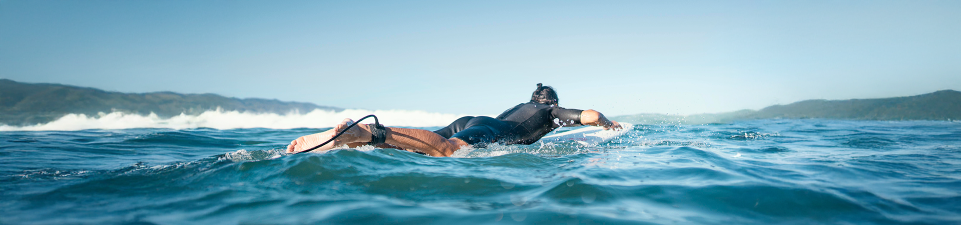 Surfista se preparando para pegar uma onda em águas claras, numa linda praia brasileira.