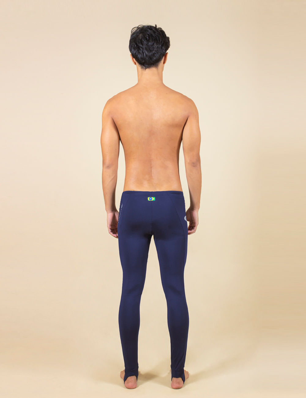 Homem usando calça sport lycra UV performance azul marinho da Greenish, vista traseira.