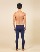 Homem usando calça sport lycra UV performance azul marinho da Greenish, vista traseira.