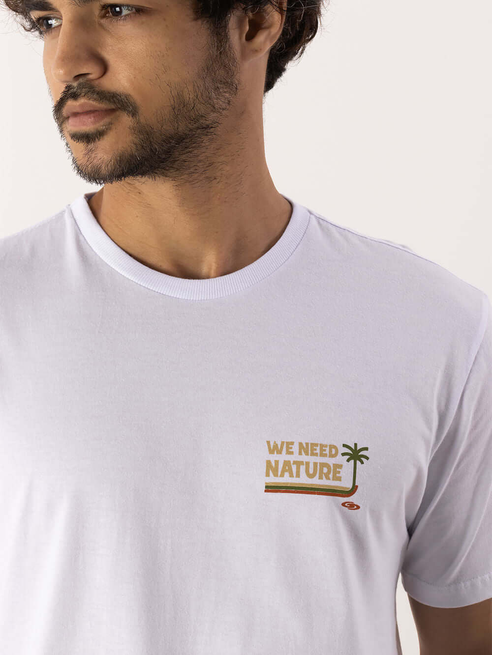Camiseta branca da Greenish com estampa "WE NEED NATURE" e detalhe de palmeira, feita em 100% algodão para conforto.