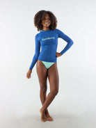 Modelo usando colete feminino Cumbuco azul da marca Greenish, posando com um sorriso.