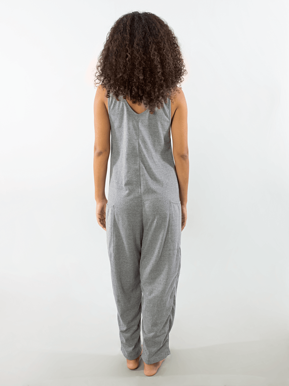 Mulher usando o macacão Yuca cinza da Greenish, vista traseira, estilo moderno e confortável.