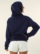 Moça usando casaco feminino azul marinho da Greenish, vista traseira, ideal para dias frios.