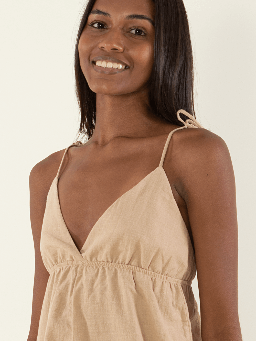 Macaquinho Kuta bege da Greenish, com alças finas e detalhe de laço, ideal para looks casuais e frescos.