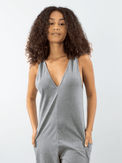 Modelo usando o MACACÃO YUCA cinza da marca Greenish, com decote em V e tecido leve.