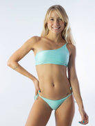 Mulher sorrindo usando biquíni verde da marca Greenish, ideal para o verão e praia.