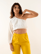 Modelo usando blusa Tati off white da Greenish, estilo moderno e elegante, com calça amarela.
