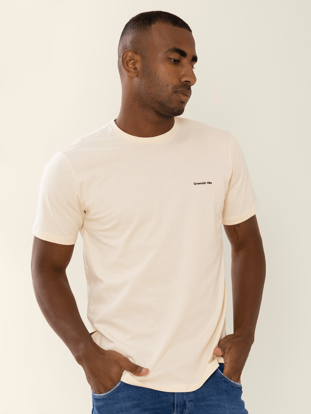 Camiseta beige minimalista com logo da Greenish, modelagem clássica, feita de algodão sustentável.