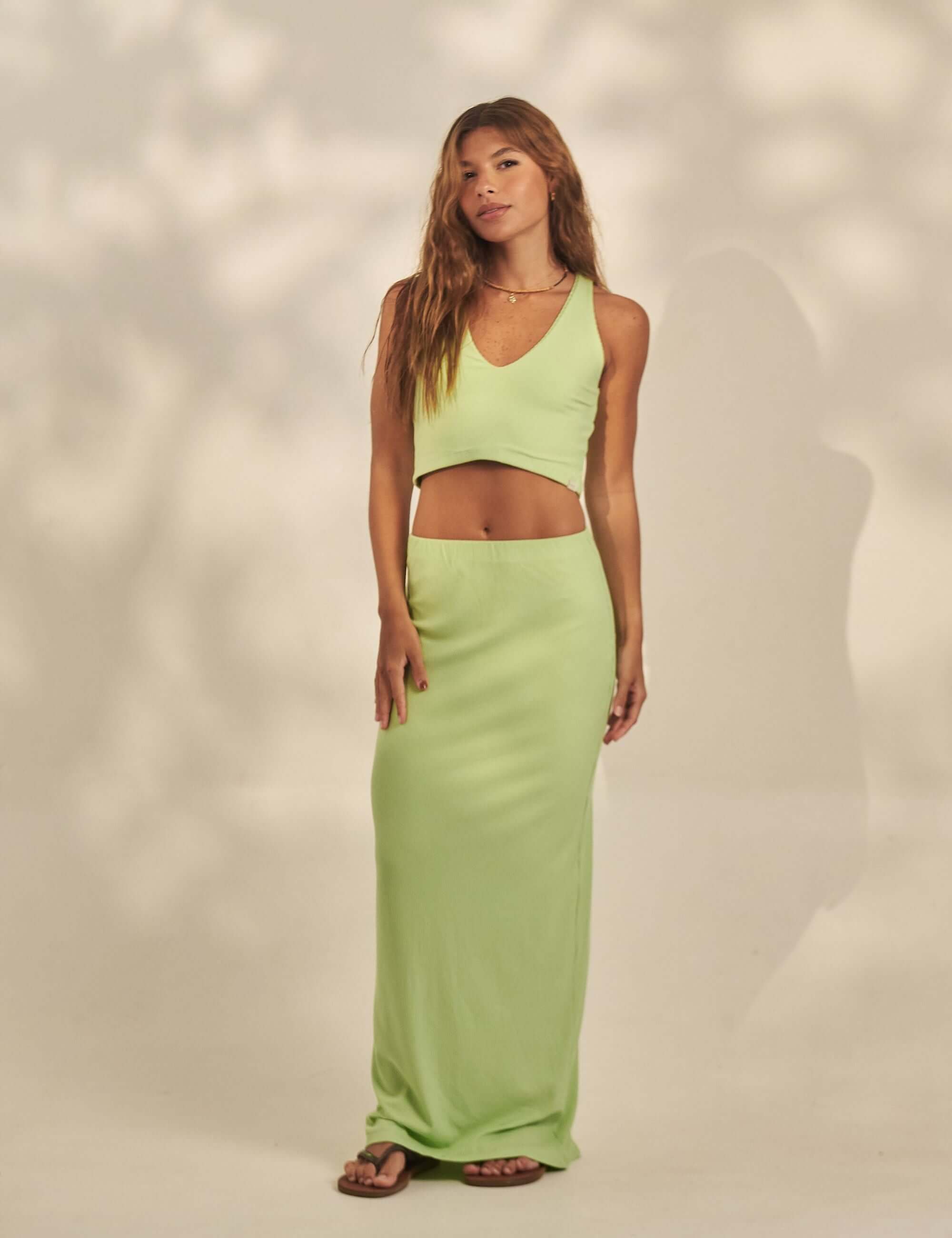 Saia Longa Canelada Emma - Verde Claro da Greenish, modelo com caimento ajustado, fenda nas costas e tecido canelado leve