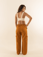 Modelo usando calça cargo sarja Gio caramel com caimento reto e cintura alta da marca Greenish.