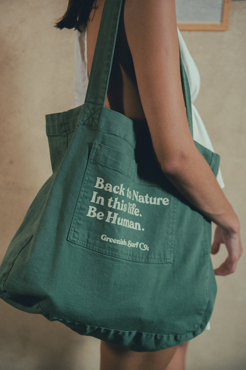 Bolsa verde com a frase "De volta à natureza. Seja humano." da Greenish Surf Co.