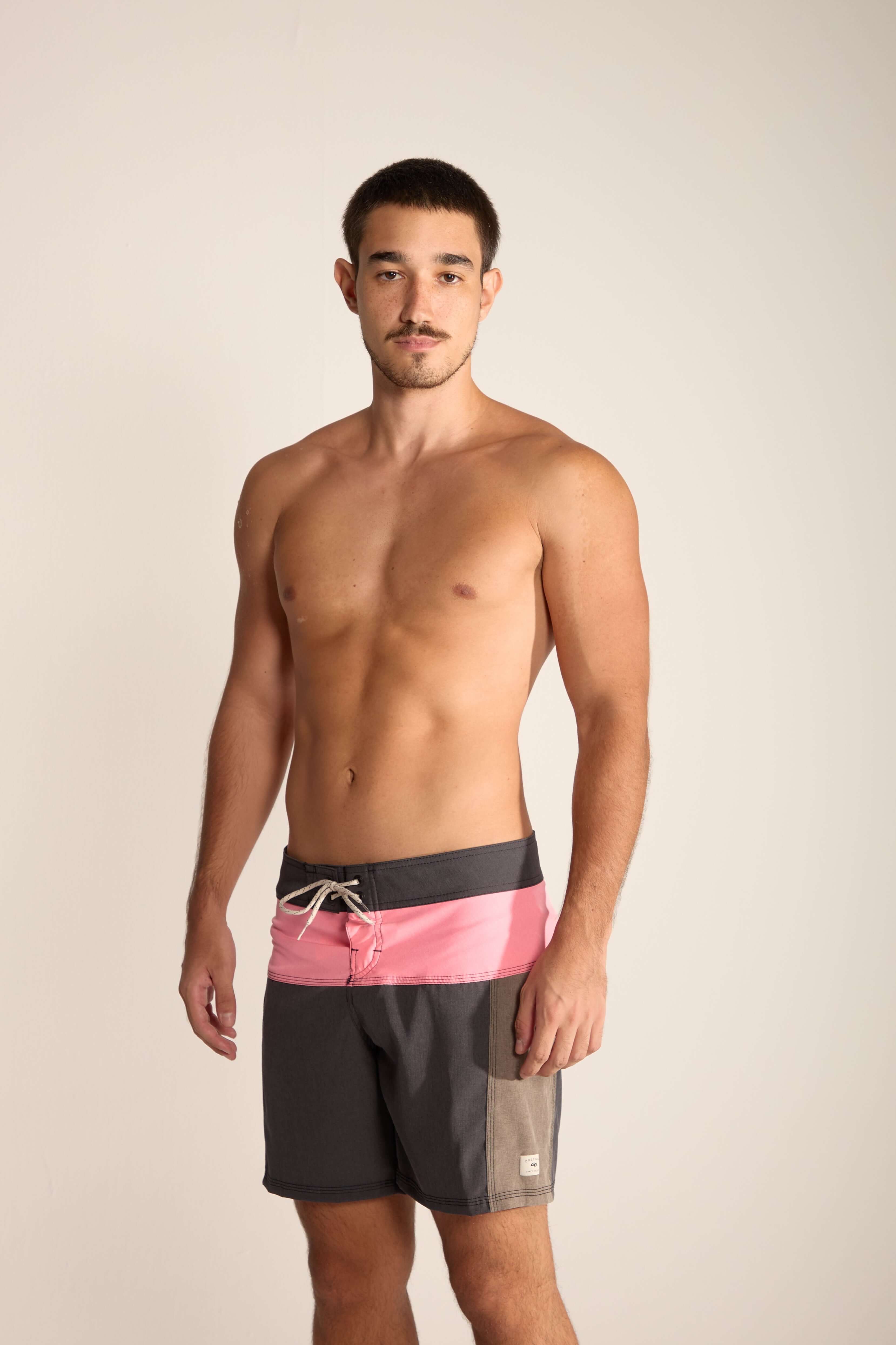 Modelo usando bermuda Boardwalk Backoutdoor da Greenish, com design moderno em tons de cinza e rosa, ideal para atividades aquáticas.