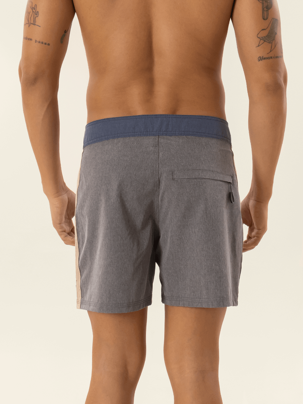 Modelo usando bermuda Boardwalk Sunshine Grafite da marca Greenish, vista traseira com detalhes em silk.