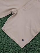 Bermuda Walkshort Classic Caqui da marca Greenish com botão e bolsos traseiros sobre fundo verde.