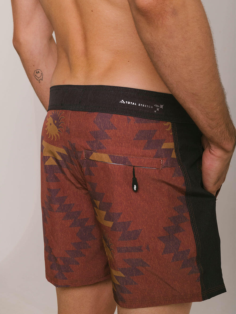 Shorts com estampa gráfica em tons terrosos, detalhe em preto e tecnologia Total Stretch, conforto e estilo para o verão.