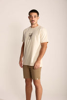 Modelo masculino usando camiseta clara e bermuda caqui, destacando estilo e conforto casual.