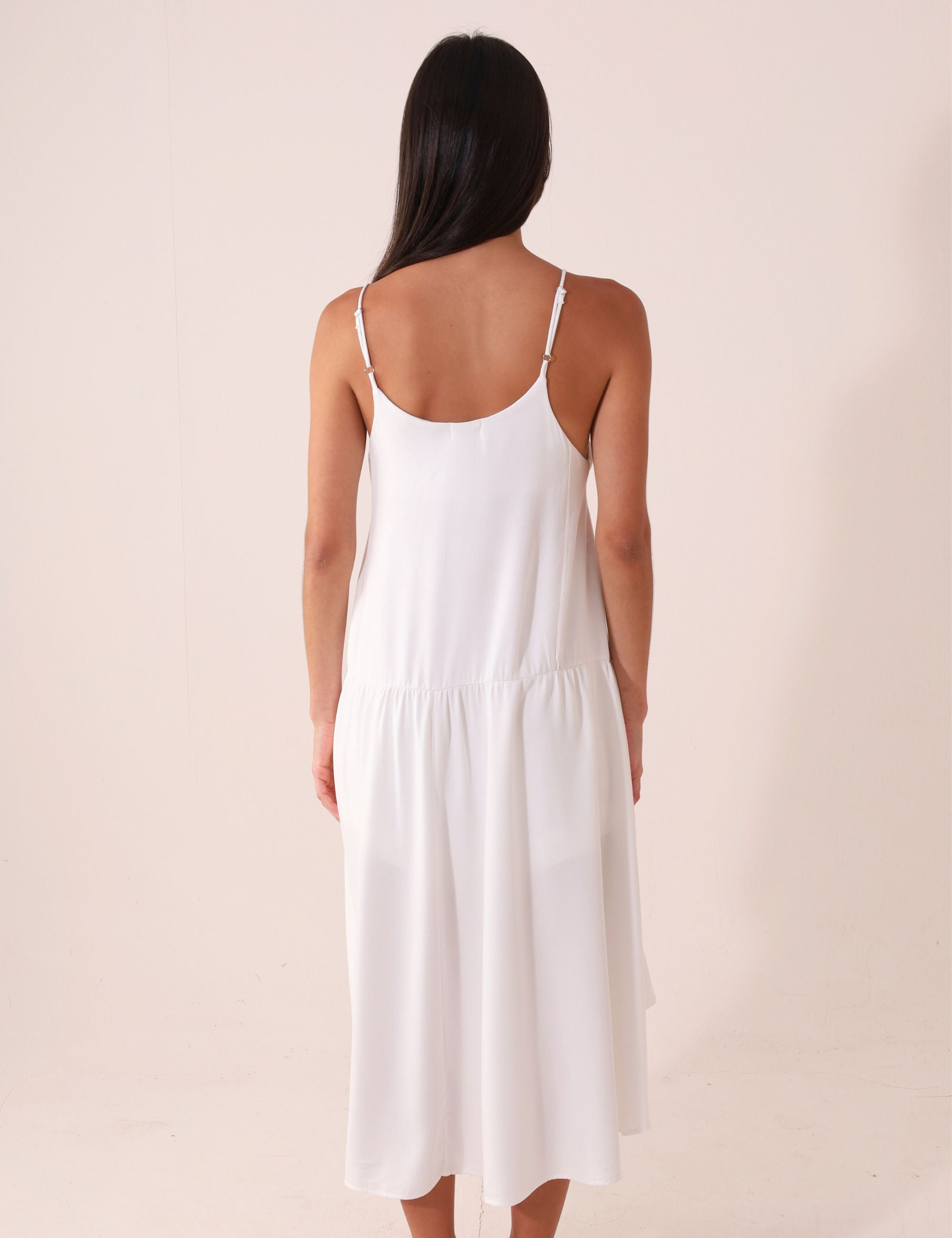 Mulher vestindo Blusa Áurea - Off White da marca Greenish, com modelagem fluida e alças finas ajustáveis. Ideal para dias de sol.